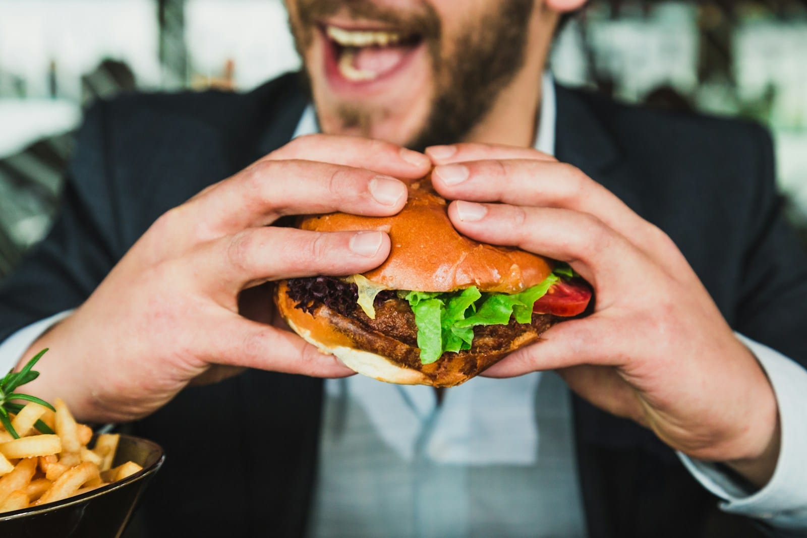 5 Platos que Todo Restaurante debe Tener y Porqué - person holding burger bun with vegetables and meat